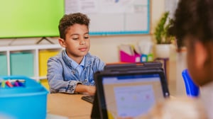 Studenti in un'aula moderna con tecnologie digitali: schermi interattivi, tablet e strumenti collaborativi per una didattica innovativa