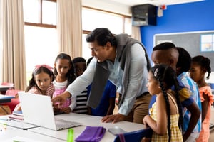 Studenti e insegnante in un'aula durante una lezione con strumenti digitali