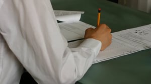 Studenti che scrivono a mano su quaderni durante un'attività in classe